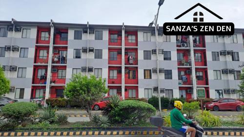 a man riding a motorcycle in front of a building at Modern 2BR Condo with Terrace,Netflix,Pool,& WiFi in Imus