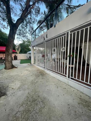 a white fence in front of a tree at Villa Tulum in San Cristóbal