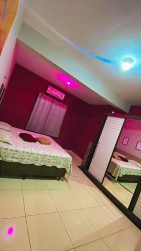 a bedroom with purple walls and a bed with a mirror at Ilha do amor in Camocim