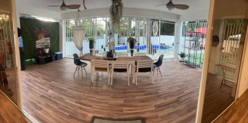 a dining room with a table and chairs on a wooden floor at Villa Tulum in San Cristóbal