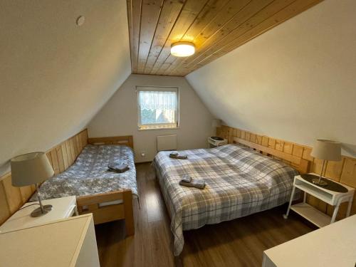 a attic bedroom with two beds and a window at BUBOVA Chata in Stará Lesná