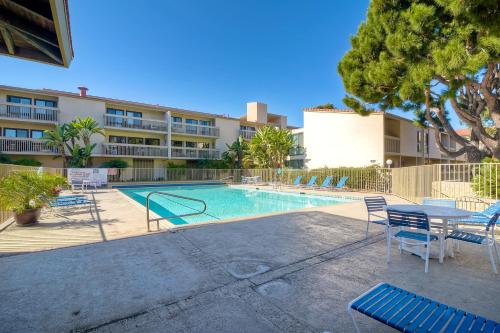 a swimming pool with chairs and a table and a building at 441 S Sierra - Unit 301 in Solana Beach