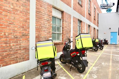 a row of scooters parked next to a brick building at City Backpackers HQ in Brisbane