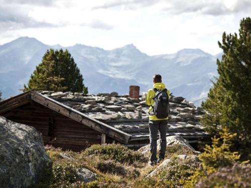a man with a backpack standing on top of a mountain at Holiday home Chalet Weberer in Stummerberg