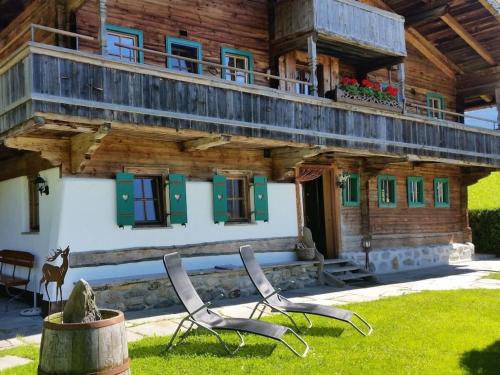 two chairs in the grass in front of a building at Holiday home Chalet Weberer in Stummerberg