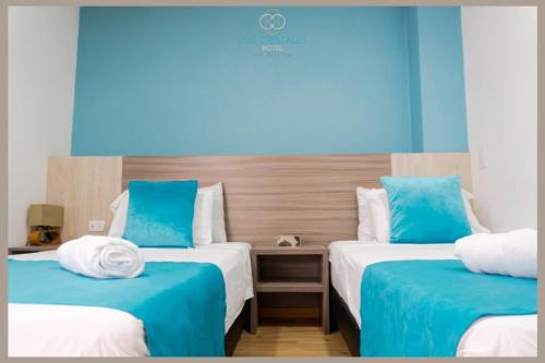 a room with two beds with blue and white at Hotel Los Cristales in Santa Rosa de Cabal