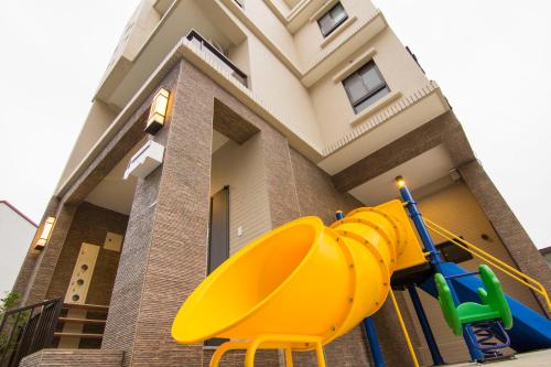 a yellow playground in front of a house at 充電樁 羅東木村電梯民宿Luodong Tree BnB 雲朵朵二館 近週三清溝 免費洗衣機 烘衣機 星巴克咖啡豆 國旅卡特約店 in Luodong