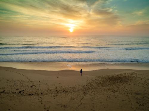 a person standing on the beach watching the sunset at Summerland 6 in Diamond Beach