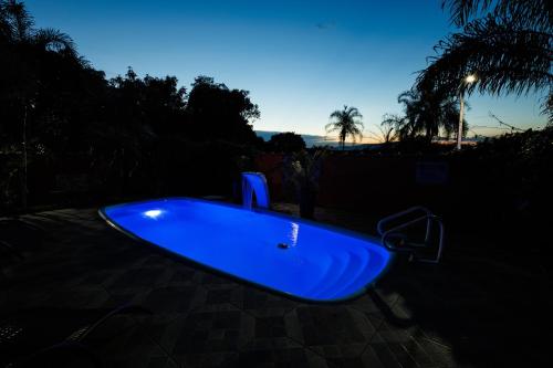 une baignoire bleue assise sur un patio la nuit dans l'établissement Chácara Beija-Flor, à Socorro