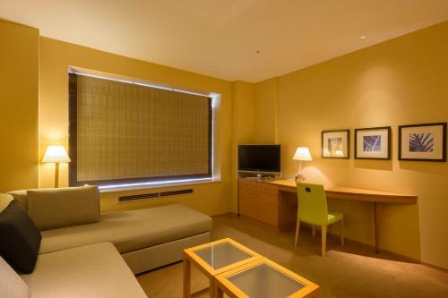 Una televisión o centro de entretenimiento en Hotel Tangram