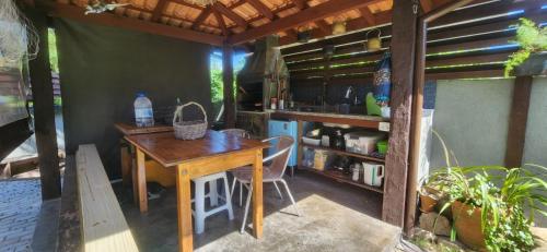 a kitchen with a wooden table and a counter at Guarda do Embau Gran Kahuna in Palhoça