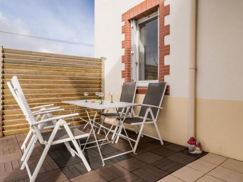 un patio avec une table et des chaises sur un balcon dans l'établissement Charmante maison rénovée, au calme avec jardin, à 20 km de la mer et 35 km de Nantes - FR-1-306-1190, à Saint-Viaud