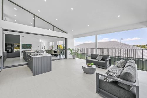 a living room with couches and chairs on a balcony at Luxury Designer Retreat - Modern, Entertainer in Orange