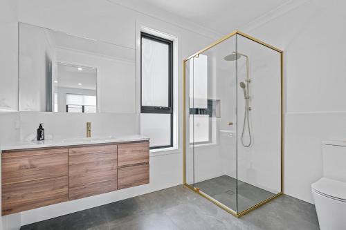 a bathroom with a shower and a sink and a toilet at Luxury Designer Retreat - Modern, Entertainer in Orange