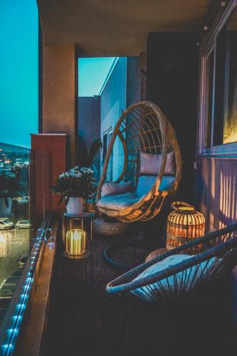 a balcony with wicker chairs and lights on a building at Artists' Nest in Marsaskala