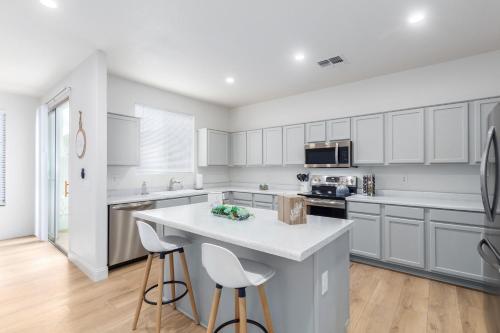 a kitchen with white cabinets and a kitchen island with stools at San Michelle Luxury Escape Mesa Pr1348 in Mesa