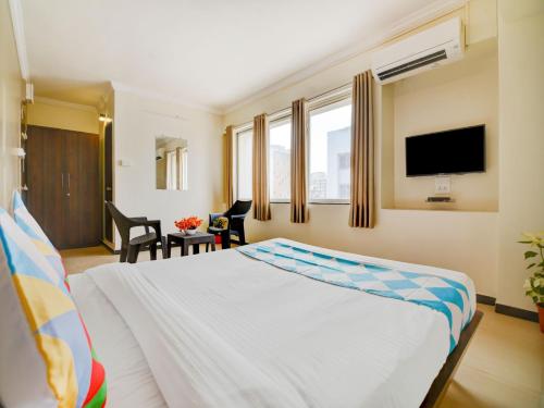 a hotel room with a bed and a flat screen tv at Hotel O Peaceful Stay Keshav Nagar. in Kharadi