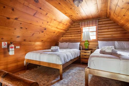 a bedroom with two beds in a log cabin at Chair 9 Chalet in Big Bear Lake
