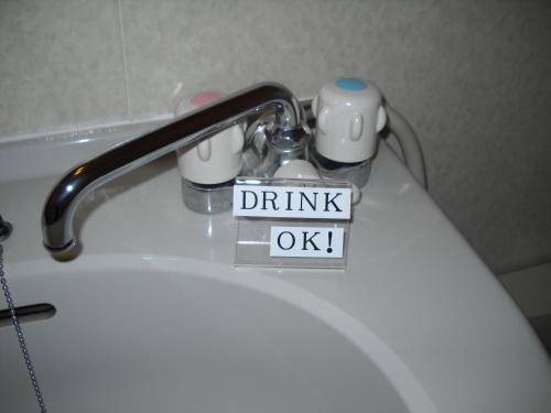 a sink faucet with a think ok sign on it at Hotel Kunimi Gotenba in Gotemba