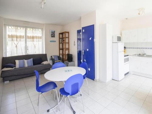 - un salon avec une table blanche et des chaises bleues dans l'établissement Stone House by Les Godelins Beach, à Gicquel