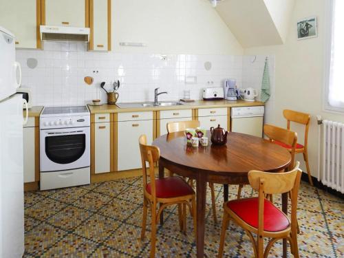 - une cuisine avec une table et des chaises en bois ainsi qu'un évier dans l'établissement Apartment in Bénodet near Sandy Beaches, à Bénodet