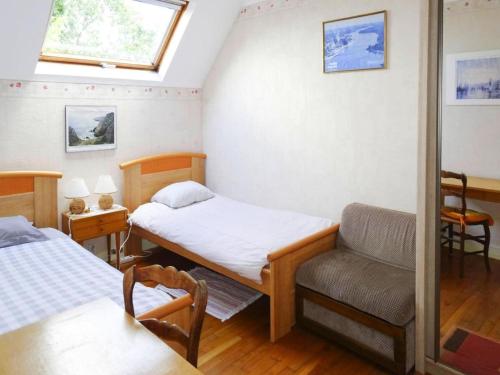 ベノデにあるApartment in Bénodet near Sandy Beachesのベッド2台と椅子が備わる小さな客室です。