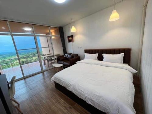 a bedroom with a bed and a view of the ocean at บ้านภูไผ่ ไร่ภูไผ่เบิกตะวัน in Ban Nam Phang