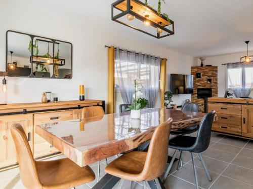 une salle à manger avec une table et des chaises en bois dans l'établissement Charmante Maison Moderne avec Jardin Privé à 9 km de la Plage, Wi-Fi et Équipements Confortables - FR-1-306-1277, à Chaumes en Retz