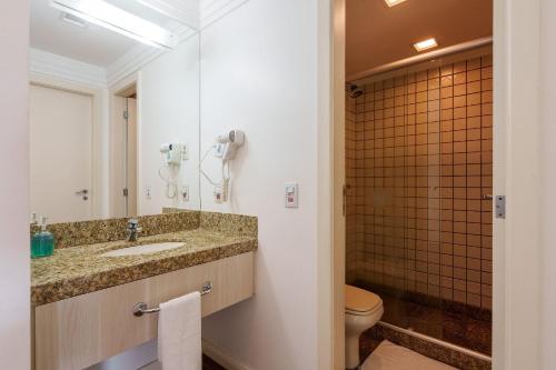 a bathroom with a sink and a toilet at Flat moderno Hotel Mercure Líder in Brasilia