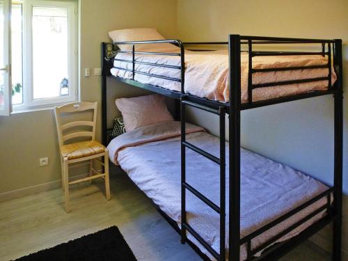 1 Schlafzimmer mit 2 Etagenbetten und einem Stuhl in der Unterkunft holiday home, Le Porge in Le Porge
