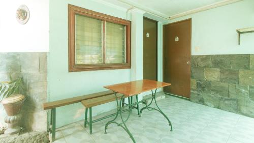 a table and a bench in a room with a window at RedDoorz at Maanyag Pension House Mandaue in Cebu City