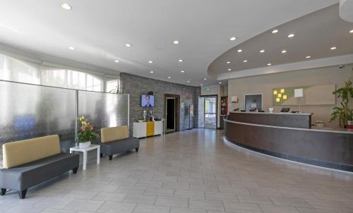 a lobby of a hospital with chairs and a counter at Pacific Stay Hotel in West Covina