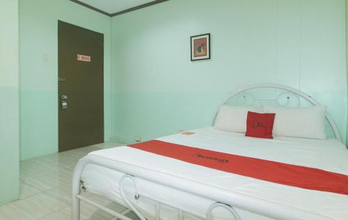 a large white bed with a red pillow on it at RedDoorz at Maanyag Pension House Mandaue in Cebu City