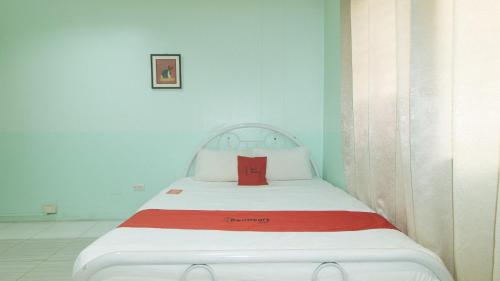 a bed in a room with a red pillow on it at RedDoorz at Maanyag Pension House Mandaue in Cebu City