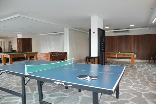 a ping pong table in a room with two tables at SALINAS EXCLUSIVE - GAV Resorts in Salinópolis