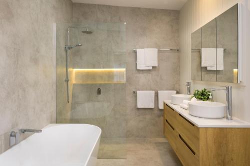 a bathroom with two sinks and a shower at Hamilton Hideaway in Hamilton