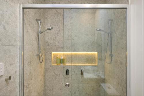 a bathroom with a shower with a glass door at Hamilton Hideaway in Hamilton