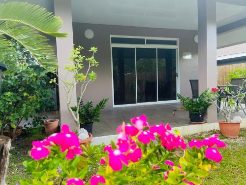a garden with pink flowers in front of a house at Lokai house in Bora Bora