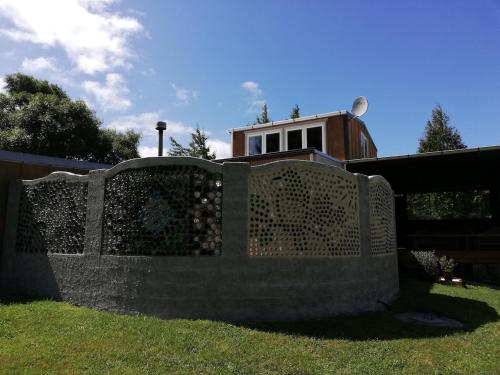 a stone fence in front of a house at Old Mountain Road Retreat in Raglan