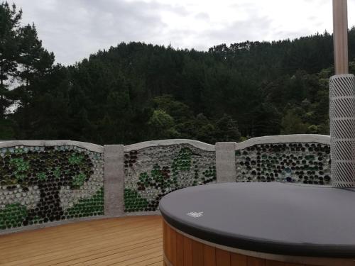 a balcony with a table and a view of the forest at Old Mountain Road Retreat in Raglan