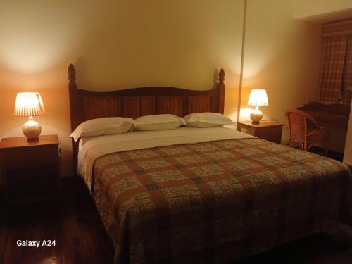a bedroom with a large bed with two lamps at Yap Pacific Dive Resort in Yaptown