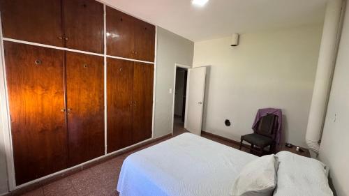 サンタ・ロサ・デ・カラムチタにあるLa casa de Renaのベッドルーム1室(ベッド1台付)、大きな木製キャビネットが備わります。