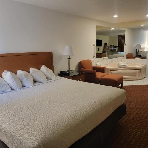 a hotel room with a bed and a living room at Days Inn by Wyndham Fort Dodge in Fort Dodge