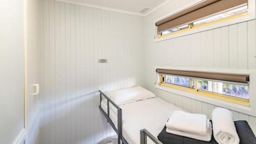 a small room with a bunk bed and a window at Ingenia Holidays One Mile Beach in One Mile