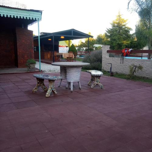 a picnic table and two benches on a patio at La Casona de Dante in Ramallo
