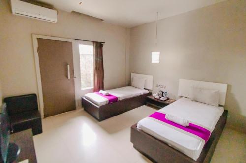 a small room with two beds and a window at Bidari Hotel Lombok in Tjakranegara