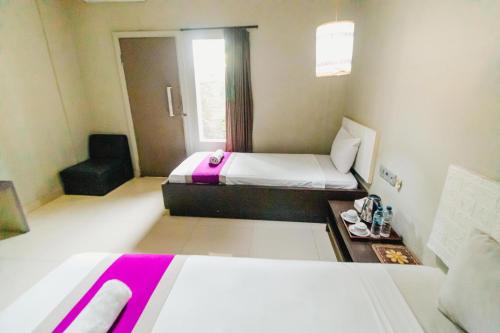 a bedroom with a bed and a chair in a room at Bidari Hotel Lombok in Tjakranegara