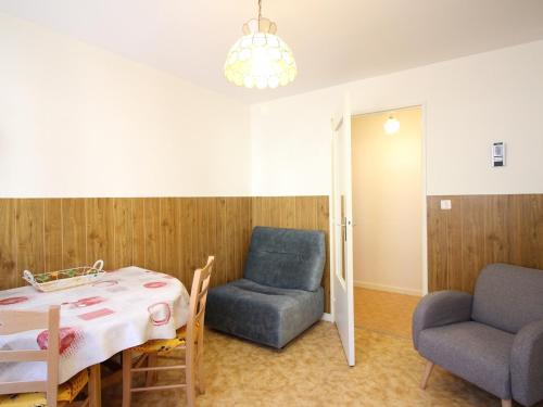 une chambre avec une table, deux chaises, une table et une chaise dans l'établissement Appartement F2 au Mont-Dore, RDC, parking privé, tout équipé, animaux acceptés - FR-1-415-101, à Le Mont-Dore