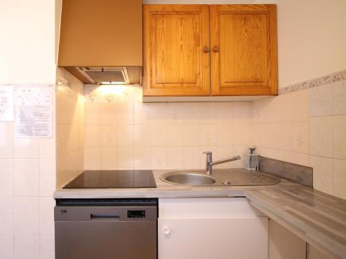 une cuisine avec un évier et un plan de travail dans l'établissement Appartement F2 au Mont-Dore, RDC, parking privé, tout équipé, animaux acceptés - FR-1-415-101, à Le Mont-Dore