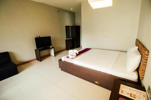 a bedroom with a bed with a stuffed animal on it at Bidari Hotel Lombok in Tjakranegara